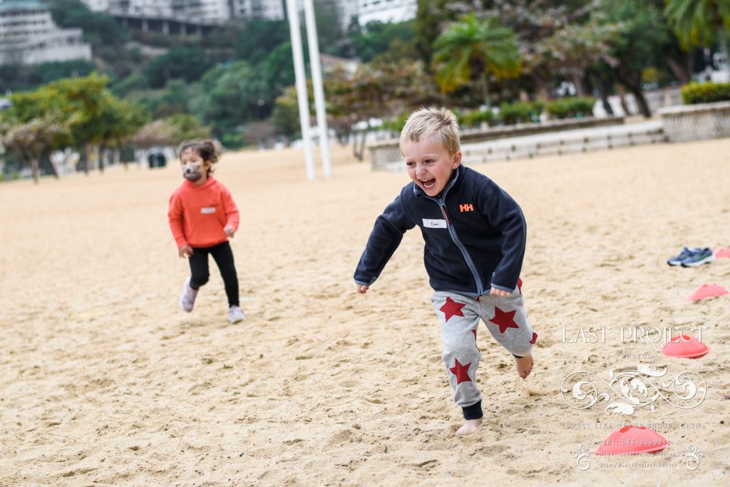 เด็กวิ่งเล่นบนทรายอย่างสนุกสนาน