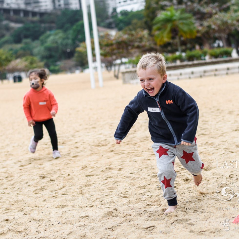 เด็กวิ่งเล่นบนทรายอย่างสนุกสนาน