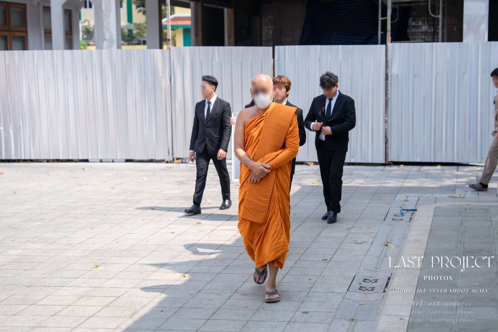 พระสงฆ์เดินนำขบวนงานฌาปนกิจศพเวียนรอบเมรุในวัดไทย A senior Thai Buddhist monk leading the funeral procession around the crematorium at a Thai temple