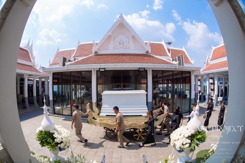 ภาพมุมสูงพิธีเวียนศพรอบเมรุในวัดไทยผ่านเลนส์มุมกว้างเห็นศาลาบำเพ็ญกุศล High-angle wide-angle view of Thai Buddhist funeral circumambulation ceremony around crematorium