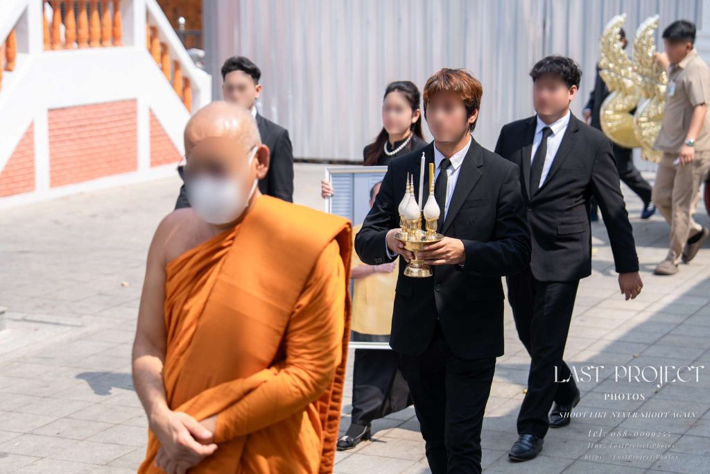พระสงฆ์และญาติเดินเวียนรอบเมรุในพิธีฌาปนกิจศพแบบไทย Buddhist monk leading the funeral procession circling the crematorium in a Thai cremation ceremony