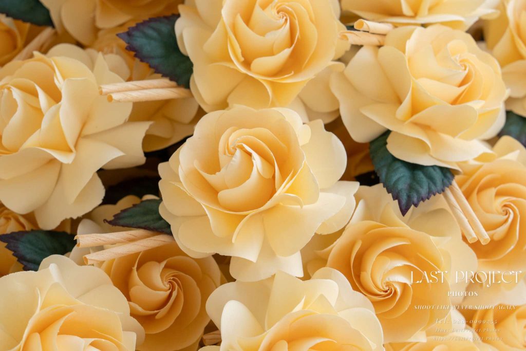 ภาพถ่ายระยะใกล้ดอกไม้จันทน์สีครีมในพิธีฌาปนกิจศพแบบไทย Close-up of traditional cream-colored artificial wood cremation flowers (Dok Mai Chan) in a Thai Buddhist funeral ceremony