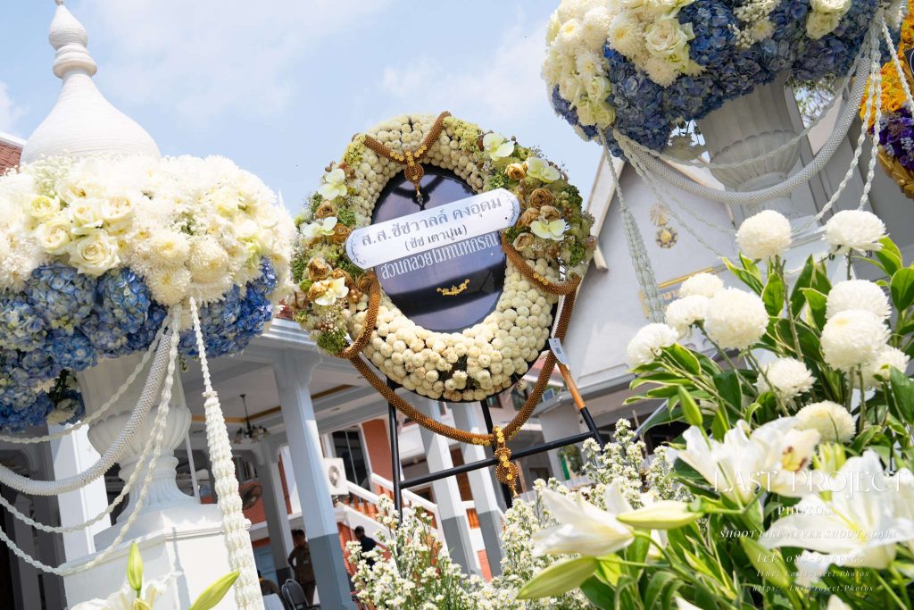 ภาพพวงหรีดดอกไม้สดหน้าเมรุในพิธีฌาปนกิจวัดไทย Funeral flower wreaths placed around the crematorium during a traditional Thai Buddhist cremation ceremony