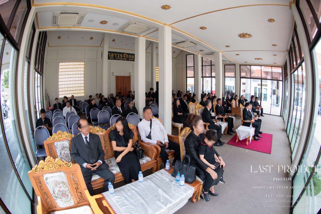 บรรยากาศแขกมาร่วมงานฌาปนกิจศพภายในศาลาวัด ถ่ายมุมกว้างด้วยเลนส์ฟิชอาย Guests attending a Thai Buddhist funeral ceremony inside a temple pavilion, captured with an ultra-wide fisheye lens.