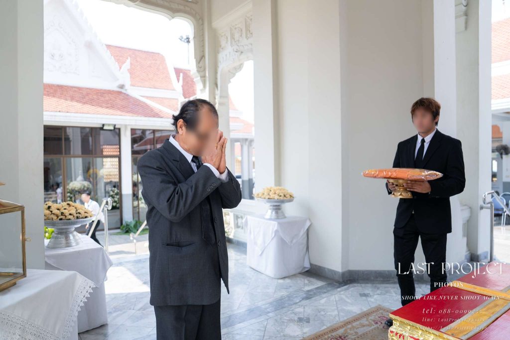 แขกผู้มีเกียรติยกมือไหว้วายชนม์หน้าหีบศพในพิธีฌาปนกิจ ณ วัดเทพศิรินทร์ กรุงเทพมหานคร Guest paying final respects with a traditional Thai wai in front of the casket during a Buddhist cremation ceremony at Wat Debsirin, Bangkok