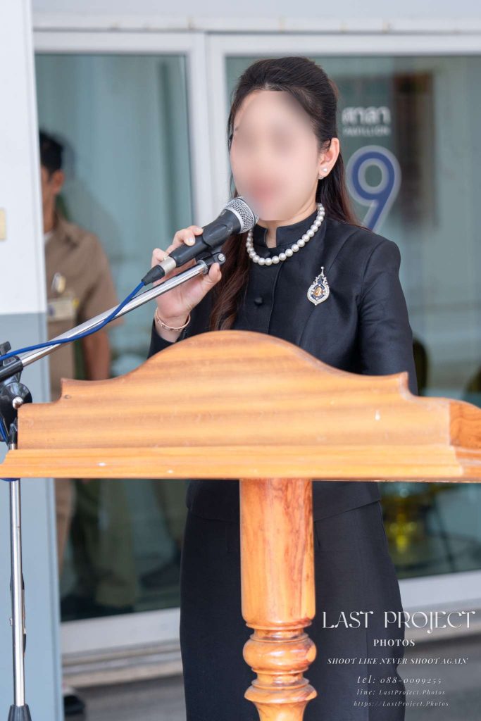 พิธีกรหญิงกล่าวไว้อาลัยในพิธีฌาปนกิจ ณ ศาลา 9 วัดเทพศิรินทร์ Female emcee giving a speech at the podium during a Buddhist funeral ceremony at Wat Thepsirin