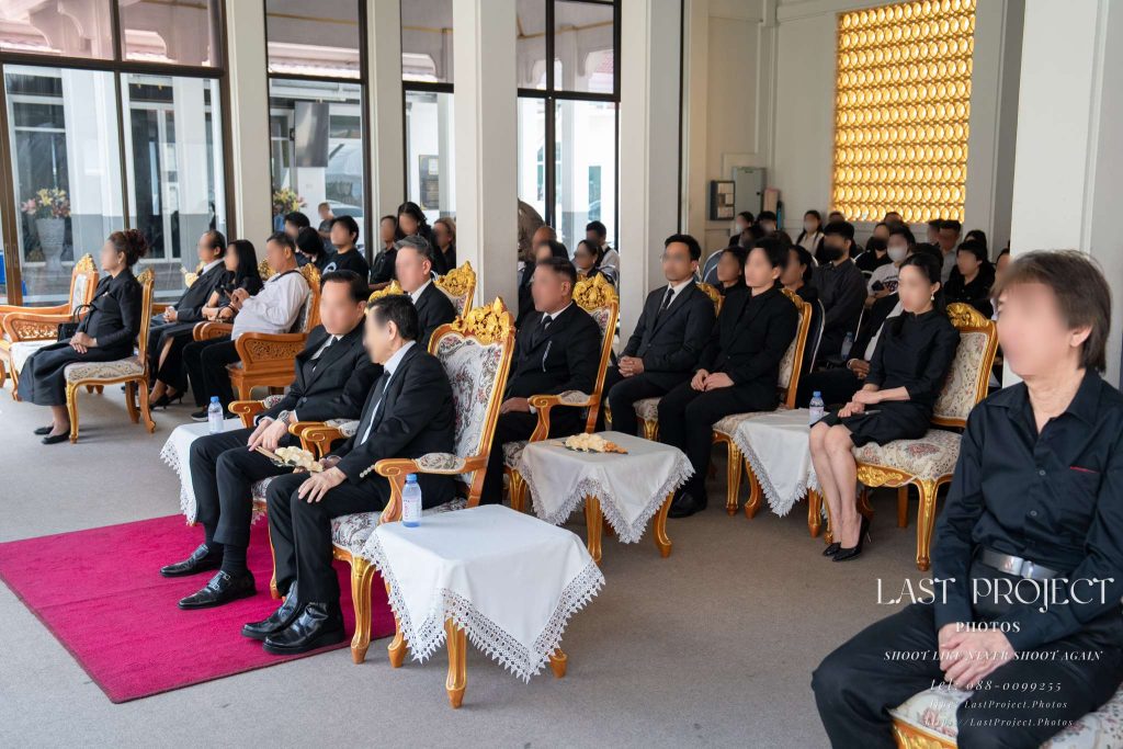 แขกผู้มีเกียรติร่วมฟังสวดและคำไว้อาลัยในพิธีฌาปนกิจศพ ณ ศาลาวัดเทพศิรินทร์ Guests seated in the pavilion listening to the eulogy during a Buddhist funeral ceremony at Wat Thepsirin