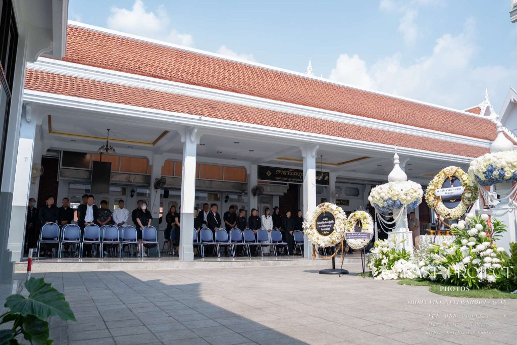 แขกผู้มีเกียรติร่วมไว้อาลัยในพิธีฌาปนกิจศพ ณ ศาลาวัด Guests attending a traditional Thai cremation ceremony at the temple pavilion