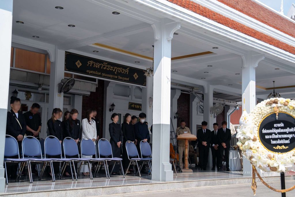 บรรยากาศแขกผู้มีเกียรติร่วมไว้อาลัยบริเวณศาลาวัดในพิธีฌาปนกิจศพ Guests gathering in solemn respect at the temple pavilion during a Thai cremation ceremony