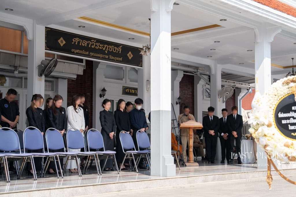 บรรยากาศพิธีฌาปนกิจศพ ญาติและแขกร่วมไว้อาลัย ณ ศาลาวีระภุชงค์ วัดเทพศิรินทร์ Guests and family gathered at the podium during a Buddhist funeral ceremony at Veerapuchong Pavilion, Wat Thepsirin Bangkok