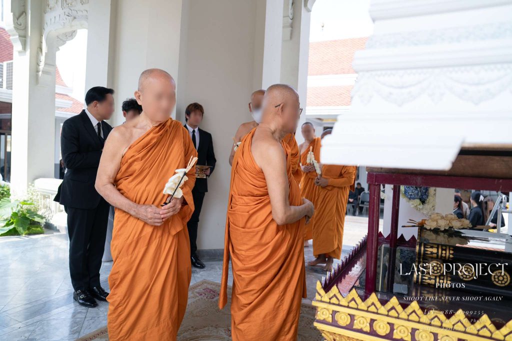 พระสงฆ์ถือดอกไม้จันทน์เตรียมวางเคารพศพในพิธีฌาปนกิจ ณ วัดไทย Buddhist monks holding sandalwood flowers to pay final respects at a Thai cremation ceremony