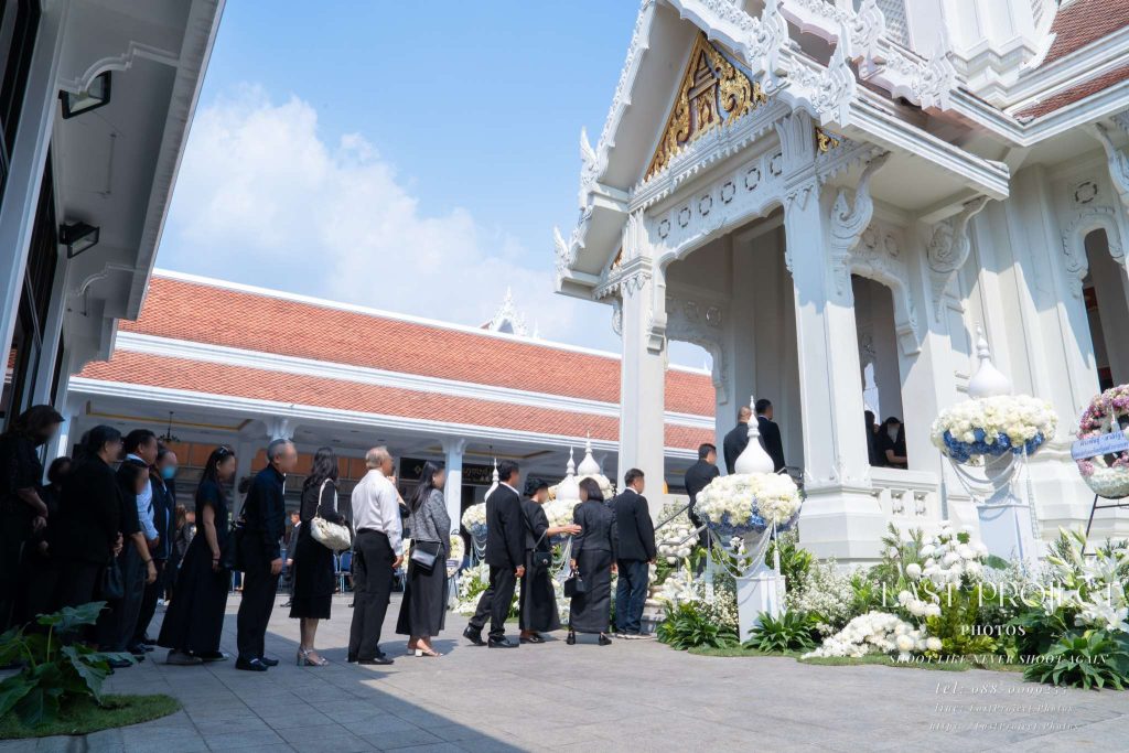 บรรยากาศทางขึ้นเมรุวัดเทพศิรินทร์ที่ประดับด้วยดอกไม้สดพร้อมแขกที่ต่อแถววางดอกไม้จันทน์ Mourners lining up at the beautifully flower-decorated crematorium stairs at Wat Debsirin in Bangkok