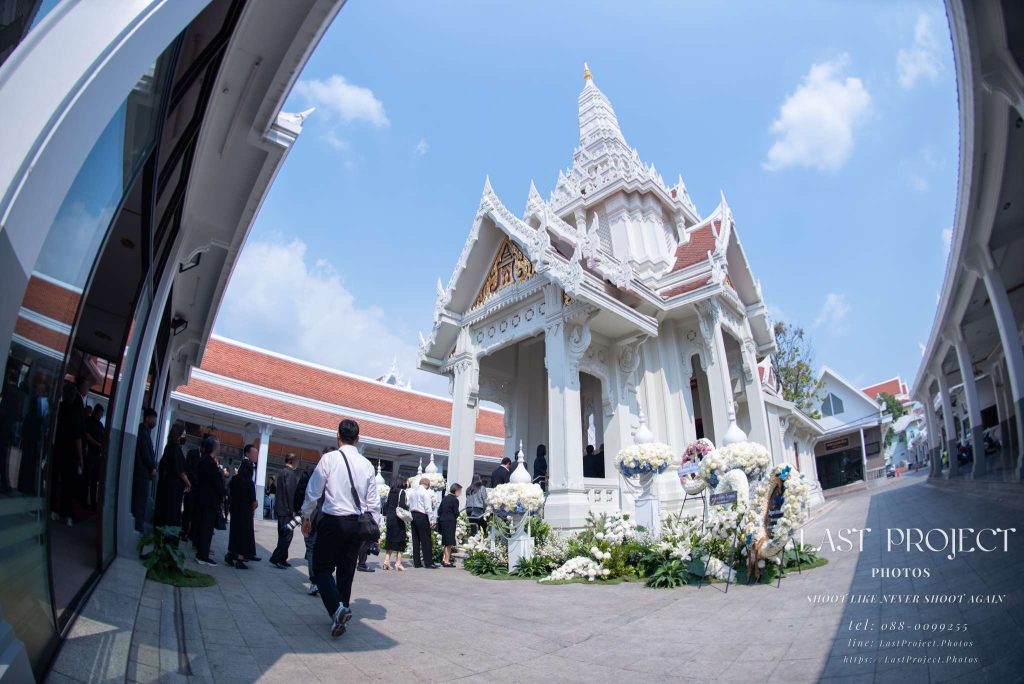 ภาพมุมกว้างพิเศษของเมรุวัดเทพศิรินทร์และแขกผู้มีเกียรติที่มาร่วมพิธีฌาปนกิจศพ Ultra-wide angle view of the crematorium architecture and mourners paying respects at Wat Debsirin cremation ceremony