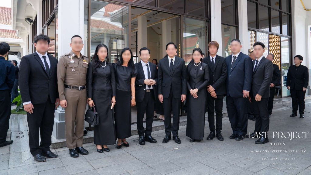 แขกผู้มีเกียรติและครอบครัวเจ้าภาพร่วมถ่ายภาพเป็นที่ระลึกในพิธีฌาปนกิจศพ ณ วัดไทย VIP guests and host family taking a commemorative photo during a Thai Buddhist cremation ceremony at a temple