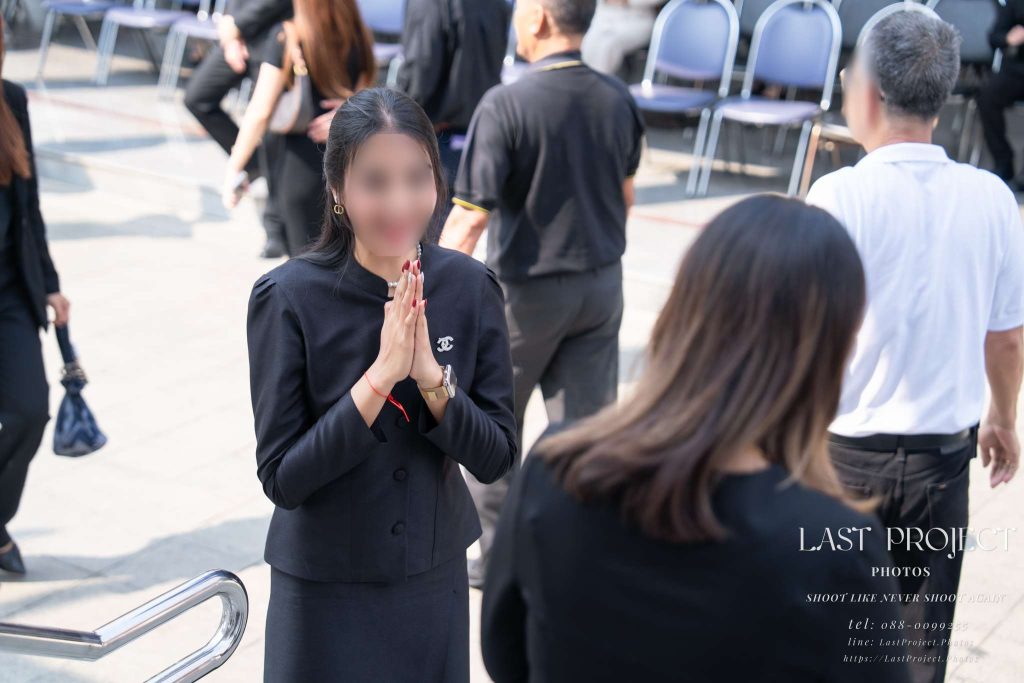 ช่างภาพบันทึกภาพแคนดิดเจ้าภาพยืนส่งแขกและไหว้ขอบคุณด้วยรอยยิ้มบริเวณทางลงเมรุ Candid funeral photography of the host family warmly thanking guests at the crematorium stairs